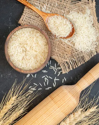 Basmati rice with paddy stalks and wooden utensils