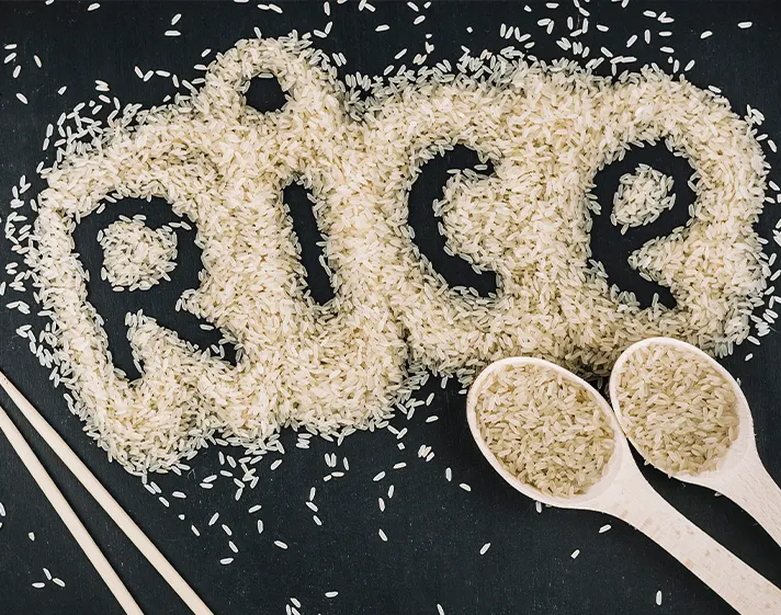 Rice grains arranged around kitchen utensils